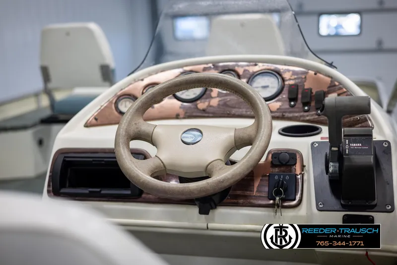 Slide: The Image of 2002 Suncruiser Trinidad 224 boat dashboard with steering wheel and controls. - 27