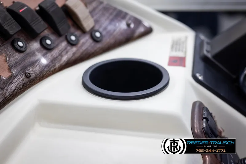 Slide: The Image of Close-up of 2002 Suncruiser Trinidad 224 boat dashboard with cup holder and control panel. - 38