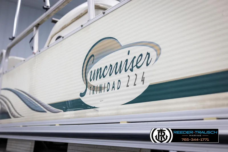 Slide: The Image of 2002 Suncruiser Trinidad 224 boat side view with logo and dealership contact. - 44