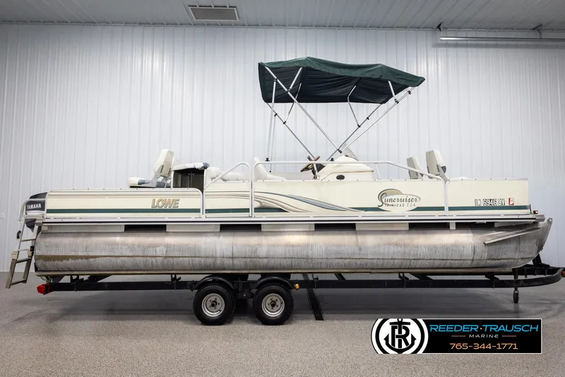 Slide: The Image of 2002 Suncruiser Trinidad 224 pontoon boat on a trailer in a storage facility. - 5