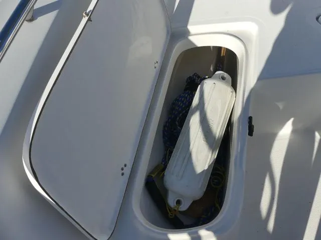 Slide: The Image of Open storage compartment on 2011 Sailfish 218 CC boat with fender and rope. - 16