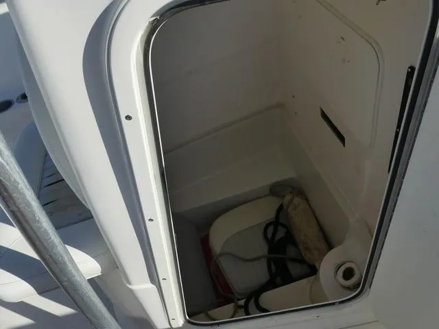 Slide: The Image of Storage compartment in 2011 Sailfish 218 CC boat, open with visible equipment inside. - 24