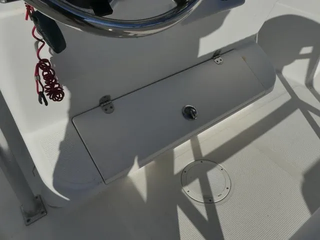 Slide: The Image of 2011 Sailfish 218 CC boat console with steering wheel and storage compartment. - 30