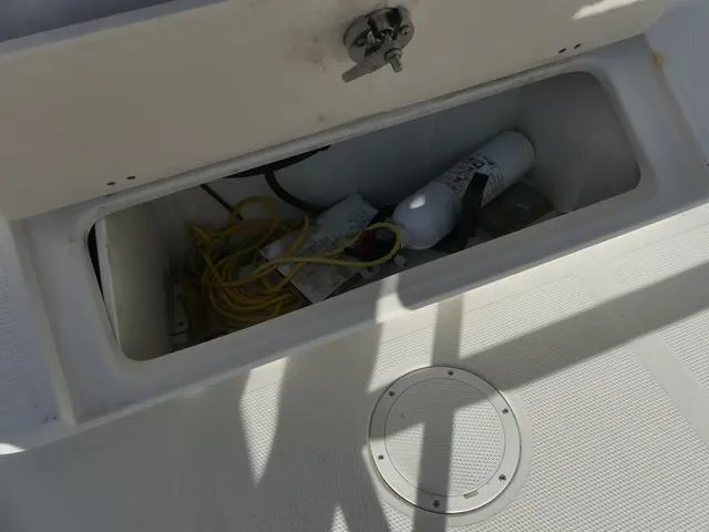 Slide: The Image of Open storage compartment on 2011 Sailfish 218 CC boat with equipment inside. - 31