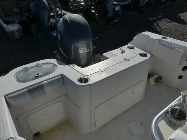 Slide: The Image of 2011 Sailfish 218 CC boat interior with Yamaha 150 engine, featuring storage and cup holders. - 33