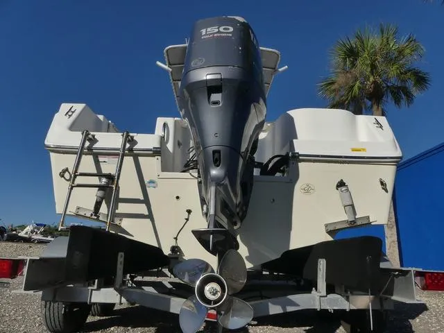 Slide: The Image of 2011 Sailfish 218 CC boat with outboard motor on trailer, palm tree in background. - 43