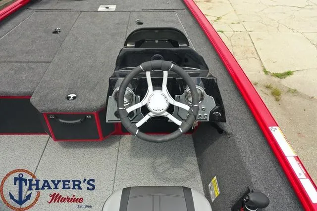 Slide: The Image of 2024 Lund 1875 Renegade SS boat interior with steering wheel, Thayer's Marine logo. - 3