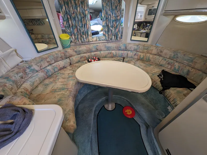 Slide: The Image of Interior of a 1995 Sea Ray 380 Sun Sport boat with a curved seating area and table. - 2