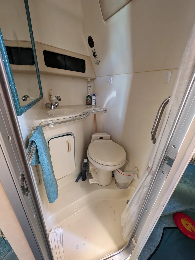Slide: The Image of 1995 Sea Ray 380 Sun Sport bathroom with toilet, sink, and storage. - 4