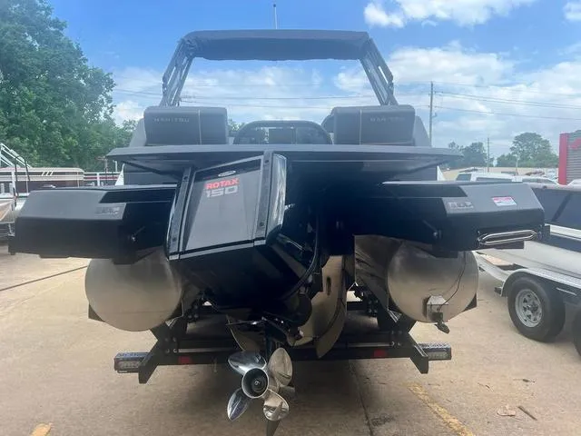 Slide: The Image of 2023 Manitou Explore 22 Bench pontoon boat with Rotax 150 engine, rear view. - 9