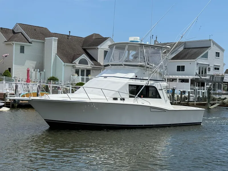 The Image of 1994 Cabo 35 Flybridge yacht near waterfront homes. - 0