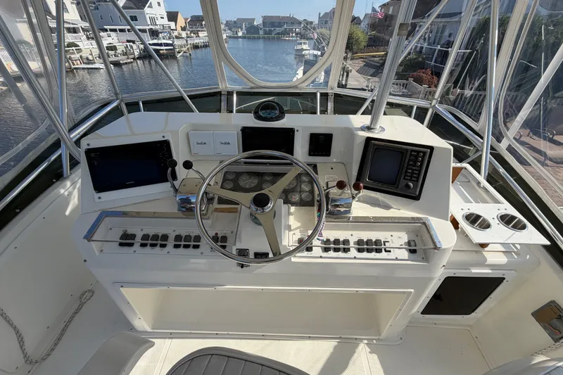 Slide: The Image of Helm of 1994 Cabo 35 Flybridge boat with steering wheel and navigation equipment. - 74