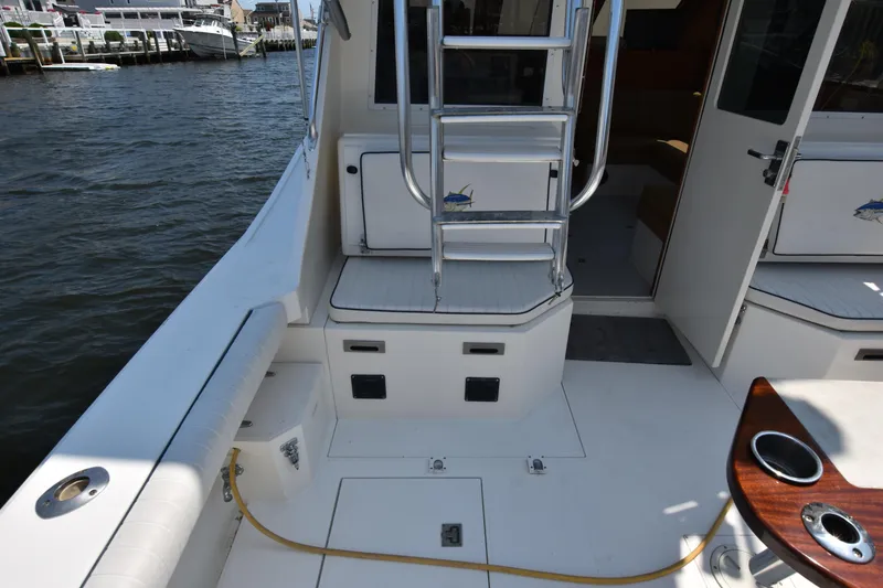 Slide: The Image of 1994 Cabo 35 Flybridge Sportfisher boat deck with ladder and seating. - 12