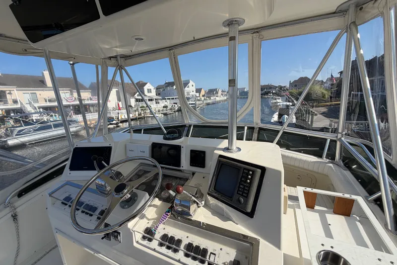 Slide: The Image of Flybridge view of 1994 Cabo 35 boat with marina backdrop. - 77