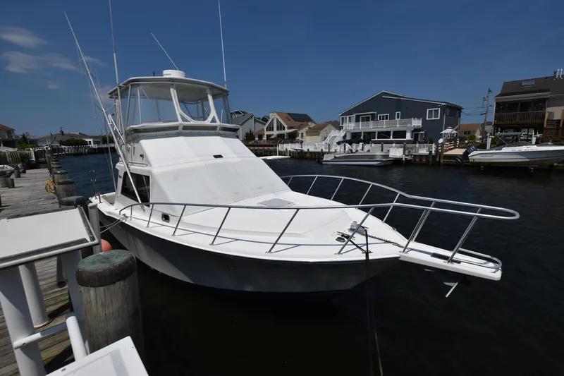 Slide: The Image of 1994 Cabo 35 Flybridge Sportfisher docked at a marina on a sunny day. - 2