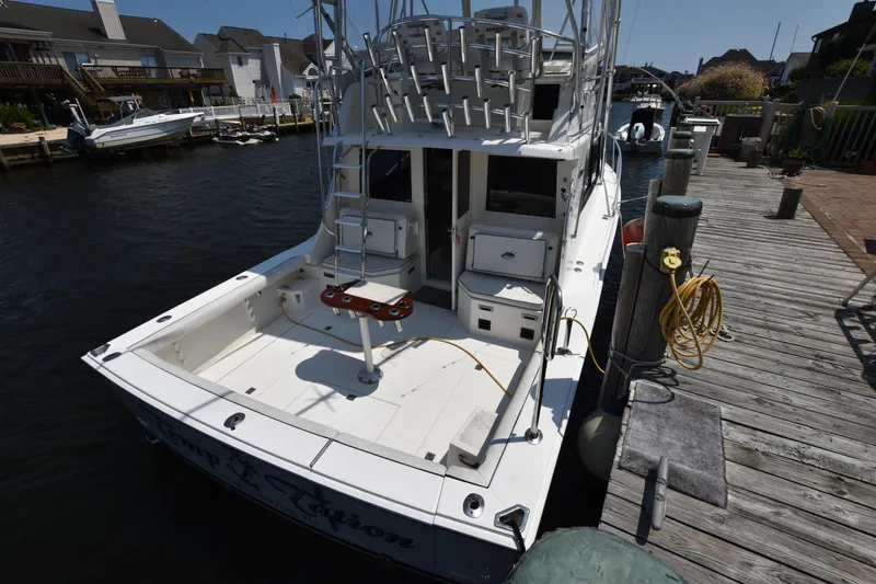 Slide: The Image of 1994 Cabo 35 Flybridge Sportfisher docked, rear view showing fishing deck and equipment. - 20