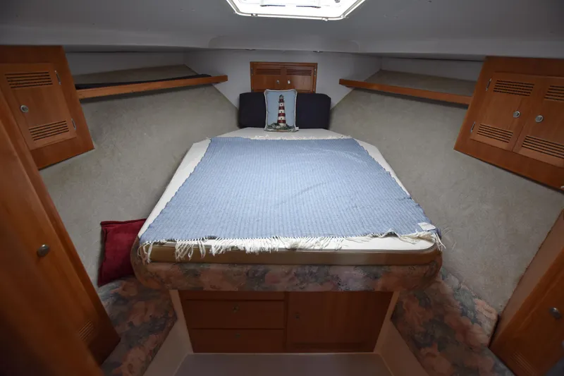 Slide: The Image of 1994 Cabo 35 Flybridge Sportfisher cabin with bed, wooden cabinets, and overhead hatch. - 45