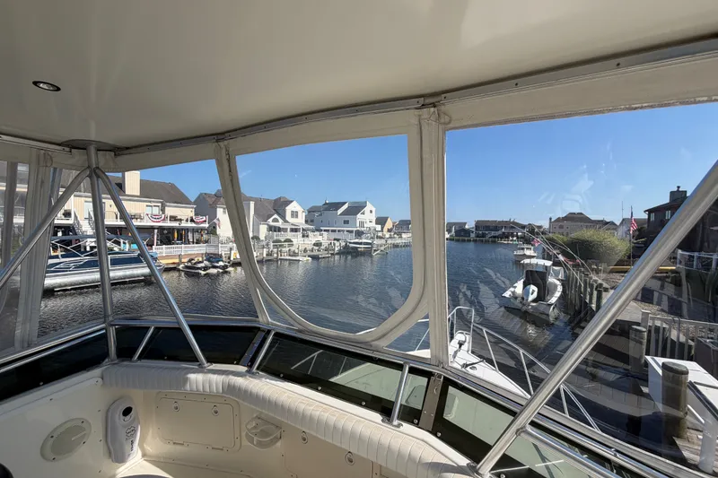Slide: The Image of View from 1994 Cabo 35 Flybridge boat overlooking a serene marina with docked boats. - 79