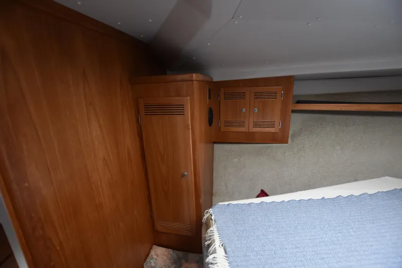 Slide: The Image of 1994 Cabo 35 Flybridge Sportfisher cabin interior with wooden cabinets and bed. - 46