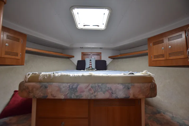Slide: The Image of 1994 Cabo 35 Flybridge Sportfisher cabin interior with bed and storage cabinets. - 48