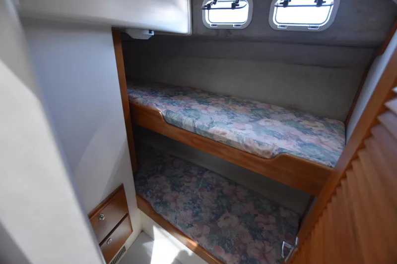 Slide: The Image of 1994 Cabo 35 Flybridge Sportfisher cabin with bunk beds and porthole windows. - 49