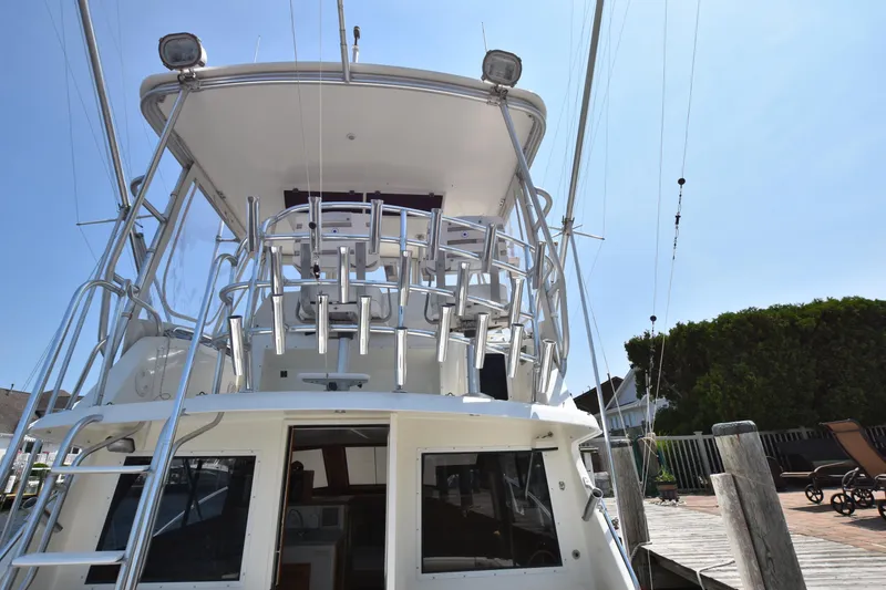 Slide: The Image of 1994 Cabo 35 Flybridge Sportfisher boat docked at a marina, rear view. - 7