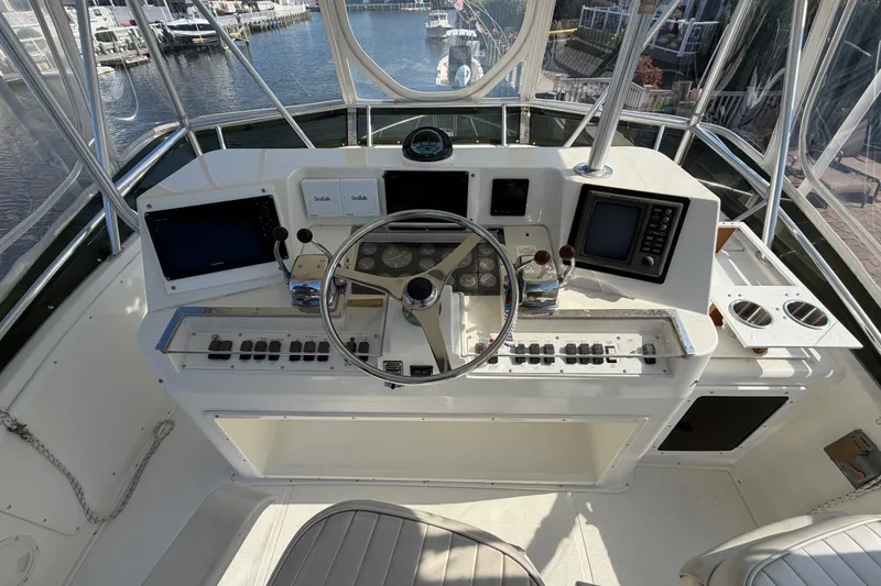 Slide: The Image of 1994 Cabo 35 Flybridge helm with steering wheel, controls, and navigation equipment. - 72