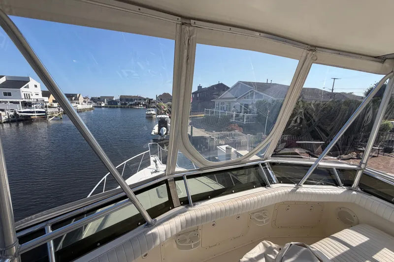 Slide: The Image of View from 1994 Cabo 35 Flybridge boat, overlooking a serene waterfront neighborhood. - 78