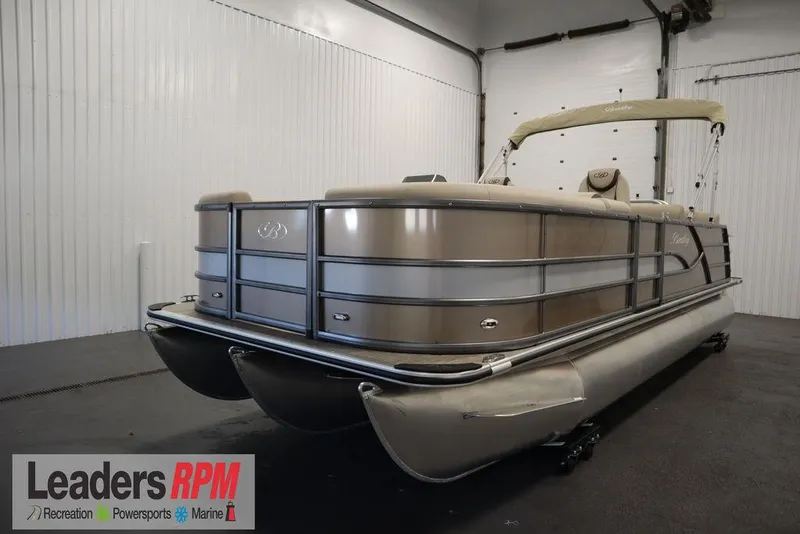 Slide: The Image of 2025 Bentley Pontoons 223 QSB Tri-Toon in showroom, beige exterior, Leaders RPM logo visible. - 1
