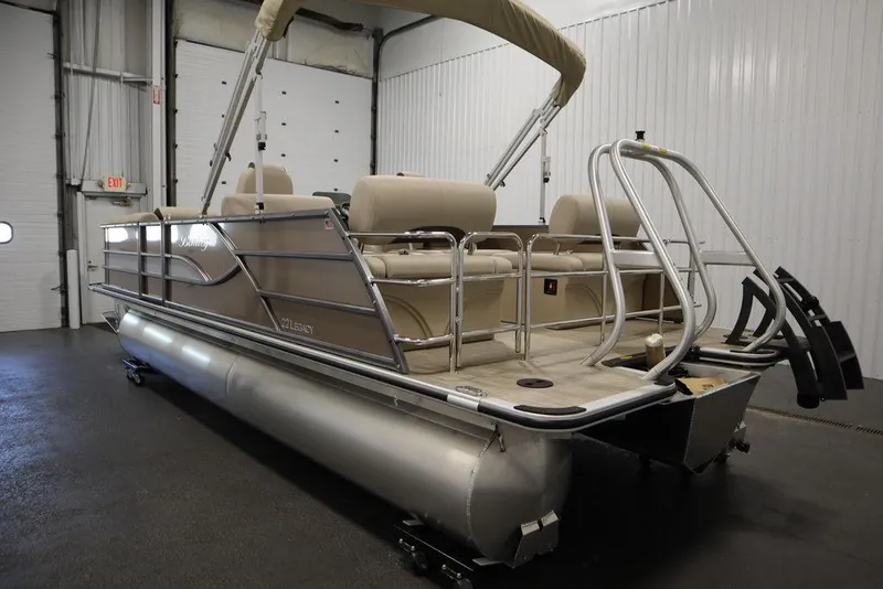 Slide: The Image of 2025 Bentley Pontoons 223 QSB Tri-Toon in indoor showroom, beige seating, sleek design. - 11