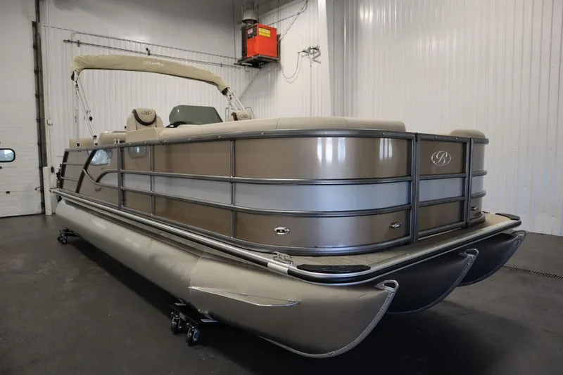 Slide: The Image of 2025 Bentley Pontoons 223 QSB Tri-Toon in a showroom, showcasing sleek design and luxury features. - 2