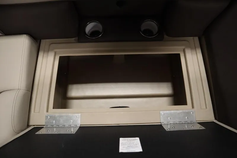 Slide: The Image of 2025 Bentley Pontoons 223 QSB Tri-Toon storage compartment with beige interior and metal hinges. - 26