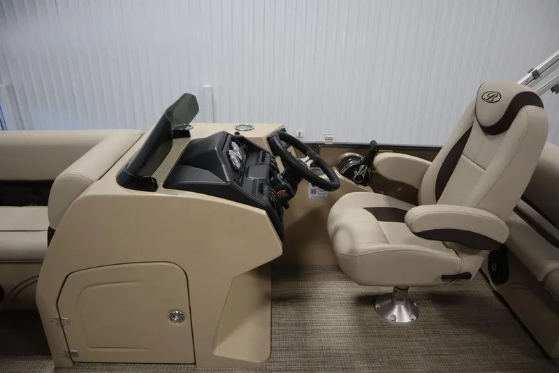 Slide: The Image of 2025 Bentley Pontoons 223 QSB Tri-Toon interior with beige captain's chair and dashboard. - 28