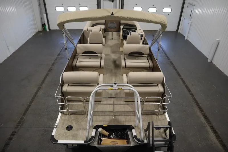 Slide: The Image of 2025 Bentley Pontoons 223 QSB Tri-Toon in a garage, showcasing spacious seating and canopy. - 9