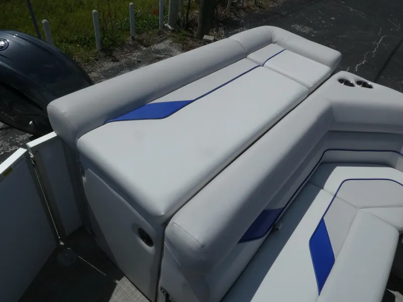 Slide: The Image of 2023 SunCatcher Select 20FC boat with gray and blue cushioned seating. - 11