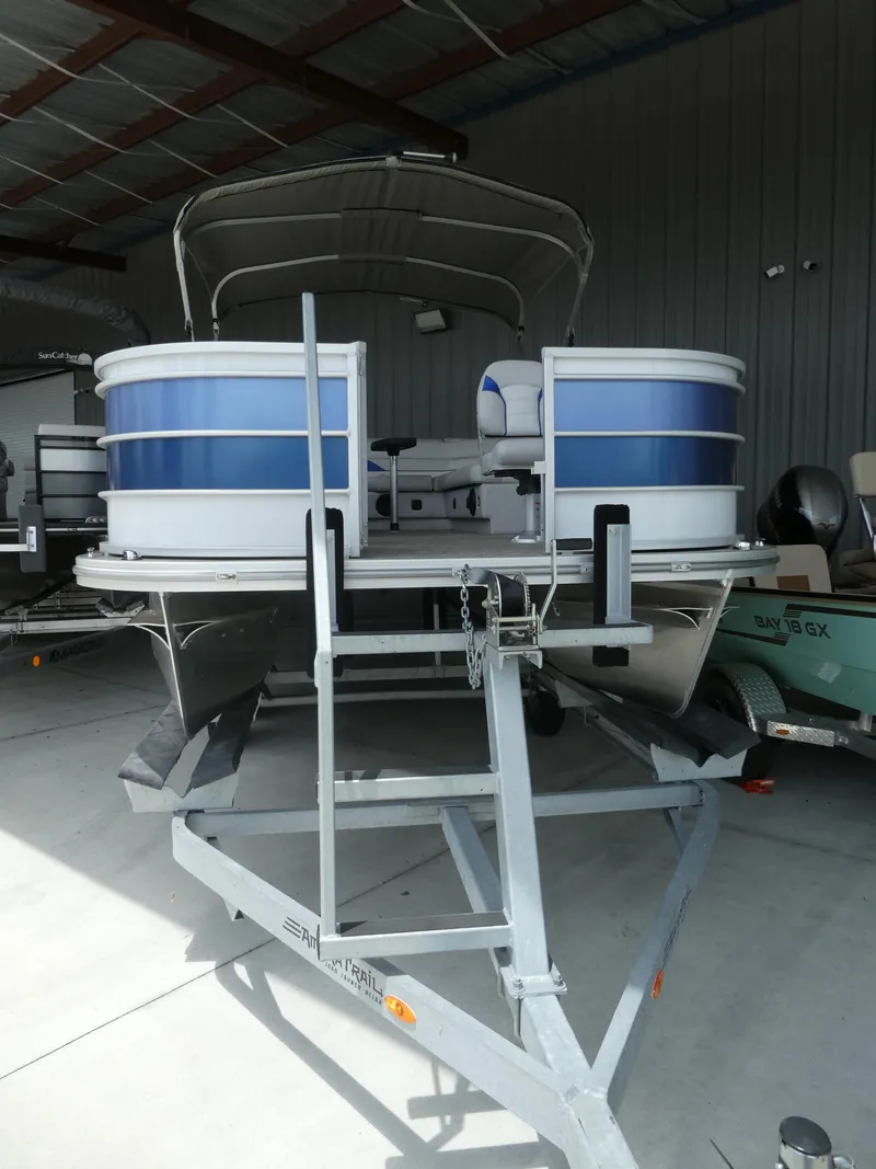 Slide: The Image of 2023 SunCatcher Select 20FC pontoon boat on a trailer in a storage facility. - 2