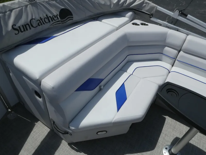 Slide: The Image of 2023 SunCatcher Select 20FC boat interior with white and blue cushioned seating. - 9