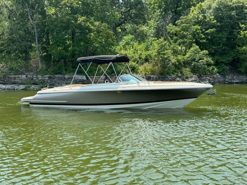 Slide: The Image of 2019 Chris-Craft Launch 27 boat on a serene lake with lush greenery. - 1