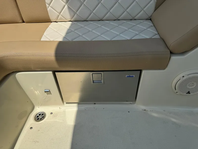 Slide: The Image of 2019 Chris-Craft Launch 27 interior seating with storage compartment and speaker. - 10