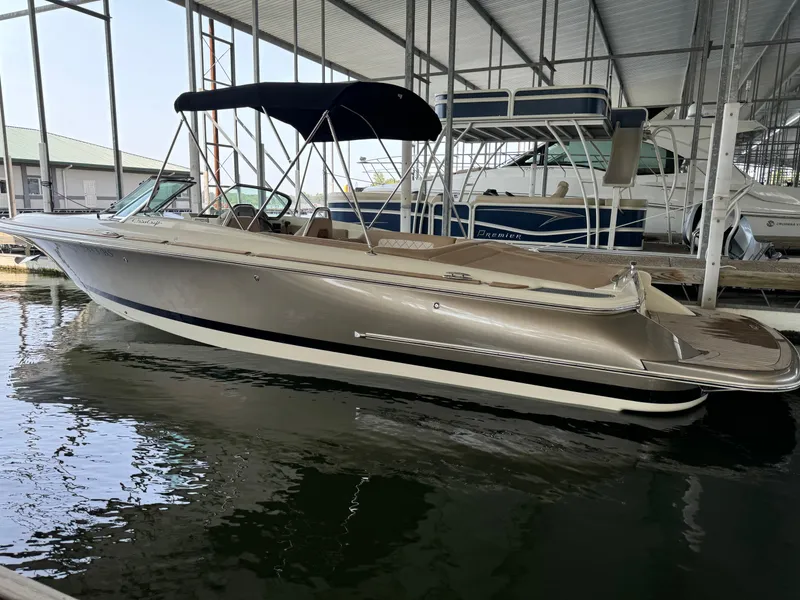 Slide: The Image of 2019 Chris-Craft Launch 27 boat docked under a covered marina. - 16