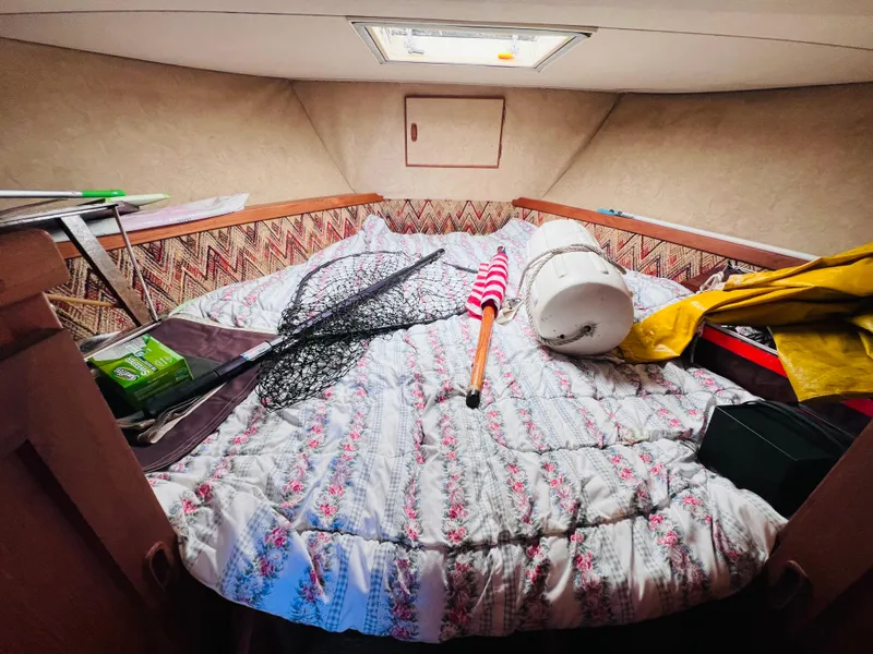 Slide: The Image of Cozy cabin interior of 1982 Trojan F32 boat with fishing gear and bedding. - 10