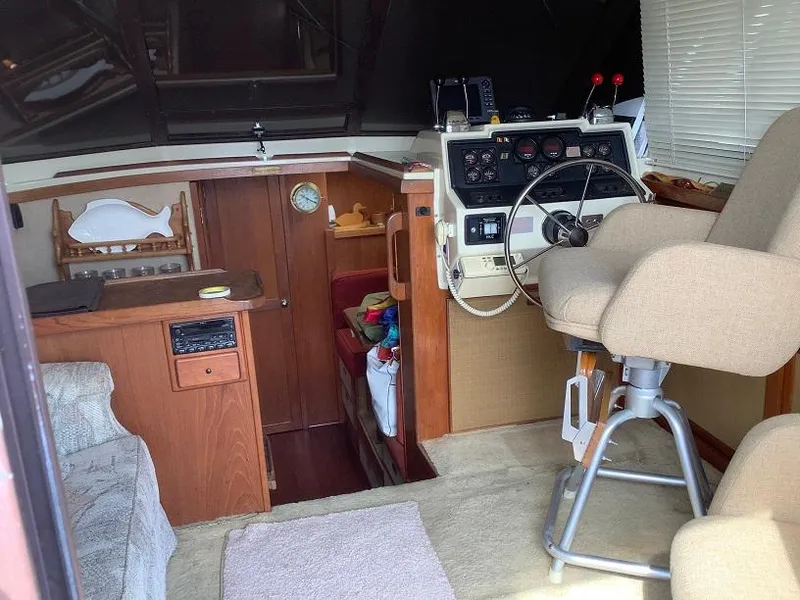 Slide: The Image of Interior of a 1982 Trojan F32 boat with helm, seating, and wooden cabinetry. - 7
