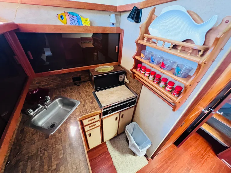 Slide: The Image of Compact kitchen in a 1982 Trojan F32 boat with sink, stove, and spice rack. - 8