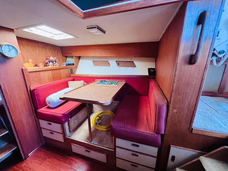 Slide: The Image of Cozy 1982 Trojan F32 boat interior with red seating and wooden accents. - 9