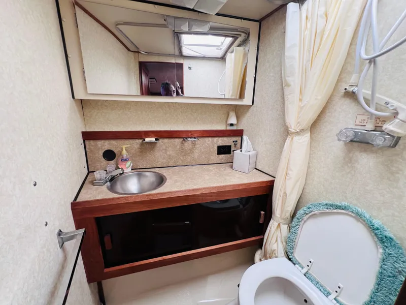 Slide: The Image of 1982 Trojan F32 boat bathroom with sink, mirror, and toilet. - 12