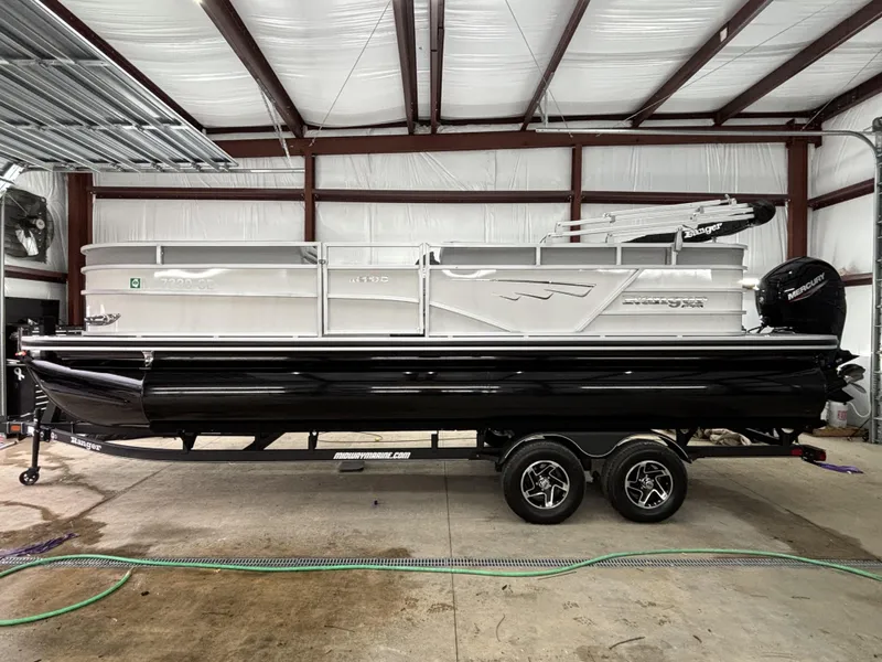 Slide: The Image of 2024 Ranger 220C pontoon boat in a garage, featuring sleek design and modern features. - 1