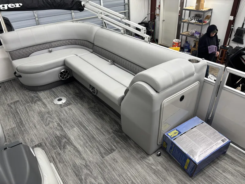 Slide: The Image of 2024 Ranger 220C boat interior with gray seating and wood-patterned flooring. - 13