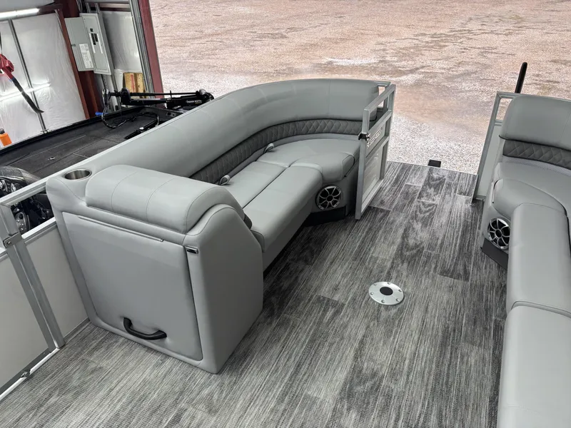 Slide: The Image of 2024 Ranger 220C pontoon boat interior with gray seating and wood-style flooring. - 17