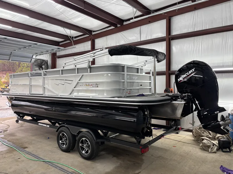 Slide: The Image of 2024 Ranger 220C pontoon boat with Mercury engine in a garage setting. - 2