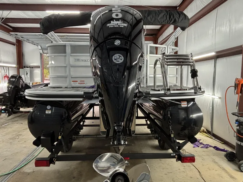 Slide: The Image of 2024 Ranger 220C pontoon boat in a garage, featuring dual outboard motors. - 3